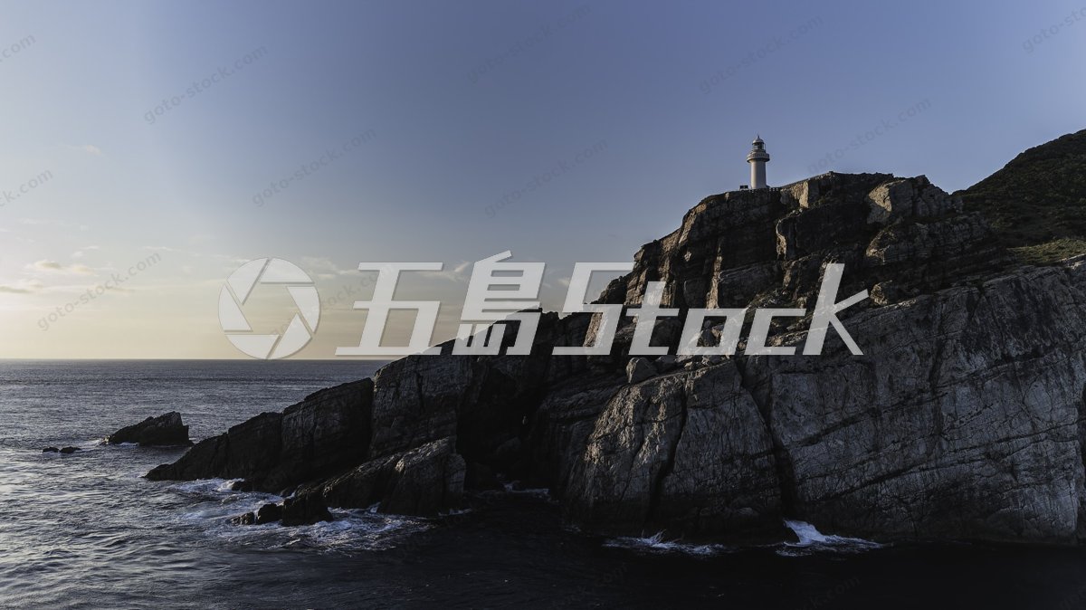大瀬埼灯台と夕暮れ時の海に臨む断崖