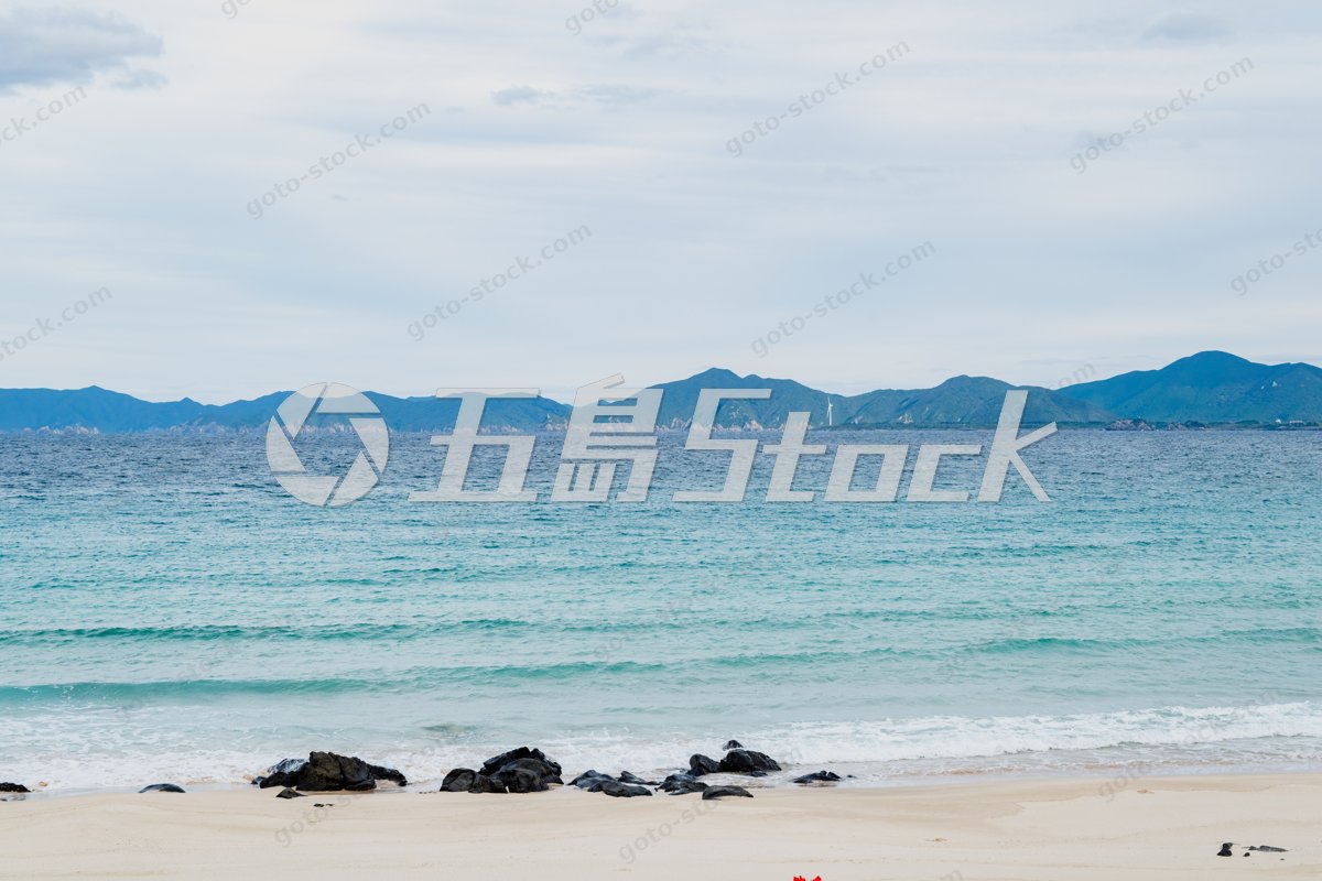 高崎ビーチの砂浜と青い海に風車が見える風景