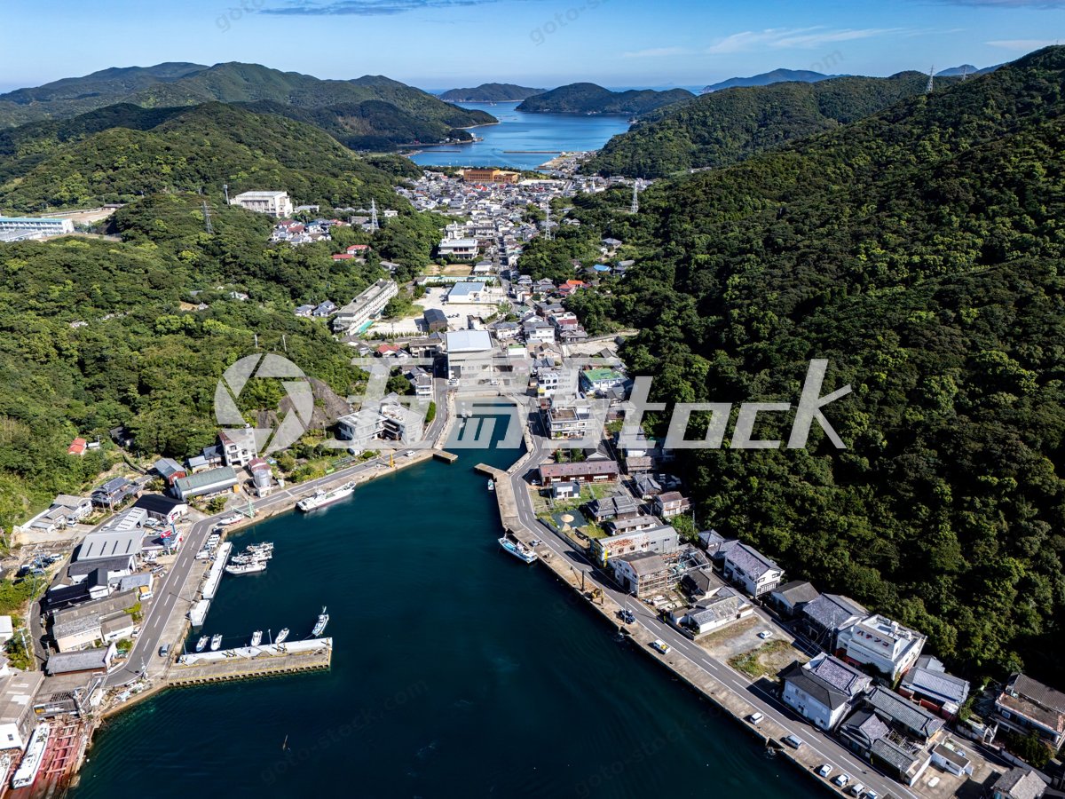 奈留島の港町と山々に囲まれた集落の空撮風景