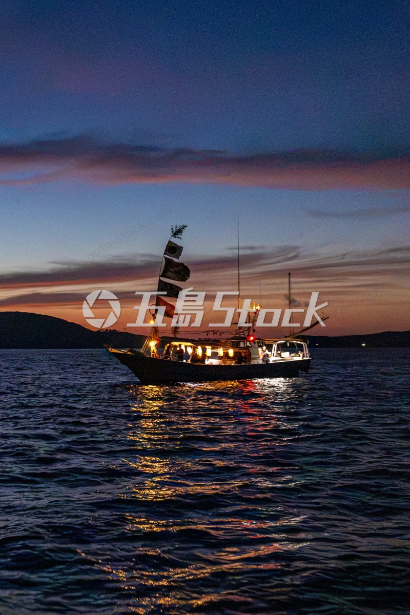 宇久島・竜神祭（ひよひよ祭）夕焼けの海に浮かぶ大漁旗の漁船