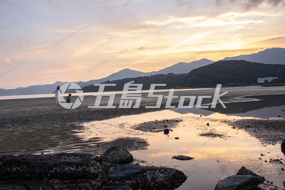 夕暮れの大浜海水浴場を歩く親子